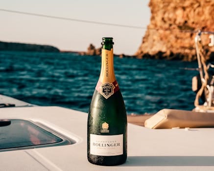 Bollinger champagne bottle on a yacht with Ibiza's ocean view, perfect for celebrations.