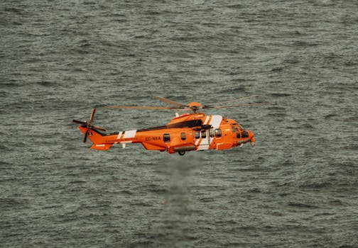 Spanish Maritime Safety helicopter flying above the ocean, offering a striking view of aerial operations.
