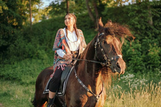A woman enjoys a serene horseback ride through a lush green landscape at sunset.