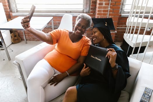 Cheerful mother and daughter taking a selfie during a graduation celebration.