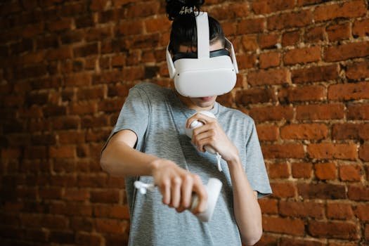 Young male teenager in casual clothes using VR headset and controllers while playing game near brick wall