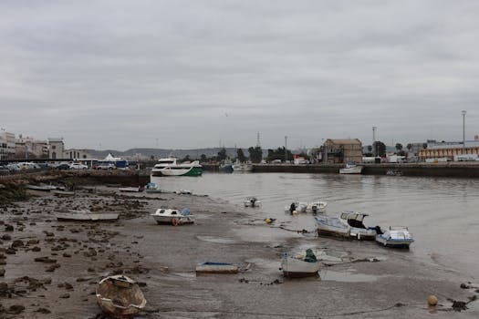 Riverbank with boats at low tide in El Puerto de Santa María, Spain.