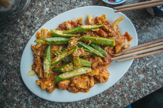 A mouthwatering dish of okra and marinated meat served on a ceramic plate, perfect for food photography.