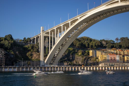 Cariere Maritime: Navigator Comercial vs. Inginer Naval - Ce ți se Potrivește Mai Bine? 2 A stunning view of Porto's Arrábida Bridge over the Douro River, showcasing architectural excellence and scenic beauty.