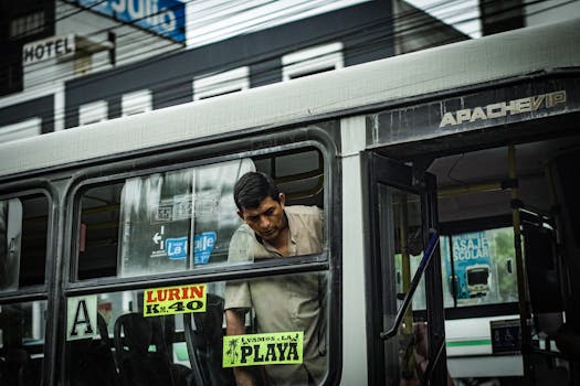 FAQ Cariere Maritime: Ghidul Complet pentru Viața la Bord și Navigație 2 A man onboard a bus in Lima, highlighting the vibrant street culture. Captured in an urban setting.