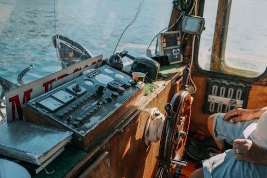Ghidul Complet al Carierei Maritime: Navigație, Viața la Bord și Oportunități Unice 4 Detailed view of a vintage boat control room, showcasing equipment and a man's arm.