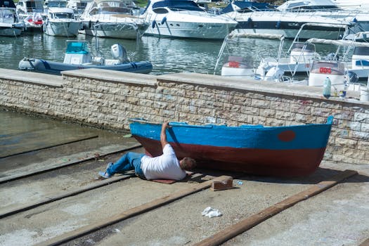 A man repairing his boat at Marinella di Selinunte marina in Sicily, Italy.