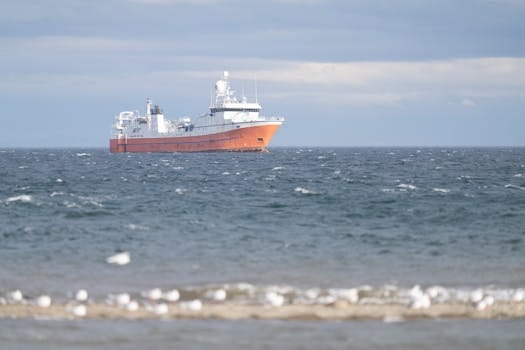 Comparație Curs Navigație Offshore Preț București vs Alte Orașe: Ghid Alegere Beneficii 3 A large freighter navigates the calm ocean waters under cloudy skies.