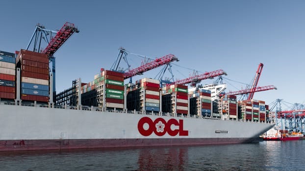 Comparație Curs Navigație Offshore Preț București vs Alte Orașe: Ghid Alegere Beneficii 4 Massive cargo ship loaded with containers at Hamburg port under clear blue sky.