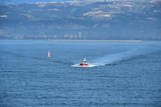 Comparație Detaliată Între Cursurile STCW Online și Offline în România 4 A speedboat glides through the Mediterranean Sea with Mersin's skyline in the background.