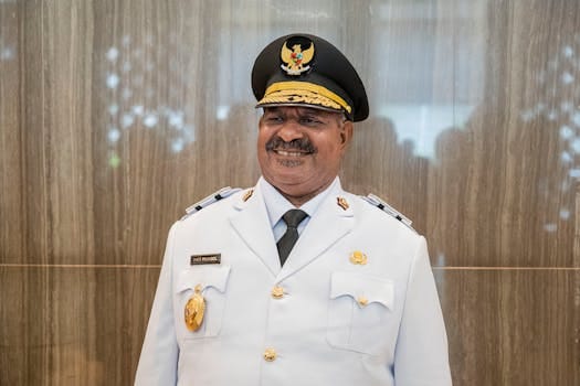 Cum să Alegi Între Certificare STCW și Diploma Electrican Maritim pentru o Carieră Sigură pe Mare 3 Indonesian military officer smiling in formal white uniform indoors, Papua, Indonesia.