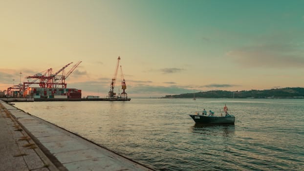 Cum să Alegi un Curs STCW care să Îți Maximizeze Oportunitățile de Carieră pe Mare în România 4 A fishing boat near a port with cranes at sunset, offering a serene view.