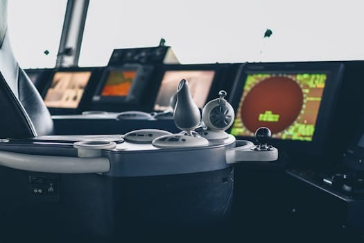 Cum să Navighezi pe Timp de Noapte: Curs Radar ARPA pentru Siguranța Navigatorilor 3 Close-up view of ship navigation controls and radar screens, capturing maritime technology.