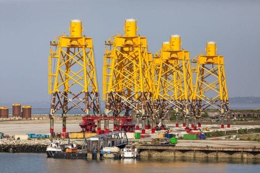 Cum să Alegi Între Școală Maritimă Internațională sau Locală pentru Certificatul STCW 3 Yellow structures in Cherbourg port, showcasing marine industrial installations in Normandy, France