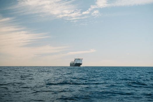 Cum să Crești Șansele de Angajare prin Curs Avansat Supraviețuire pe Mare Complet 2 A cargo ship sailing on the calm waters of Baja California Sur, México, under a clear sky.