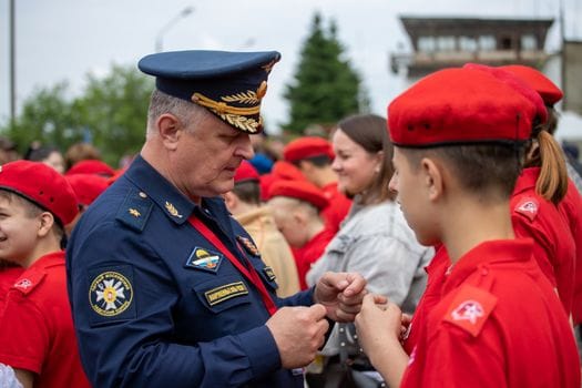 Cum să Obții Certificarea Avansată ca Ofițer Mecanic de Navă: Ghid Complet 2 A military officer engages with youth cadets in uniform at an outdoor event.