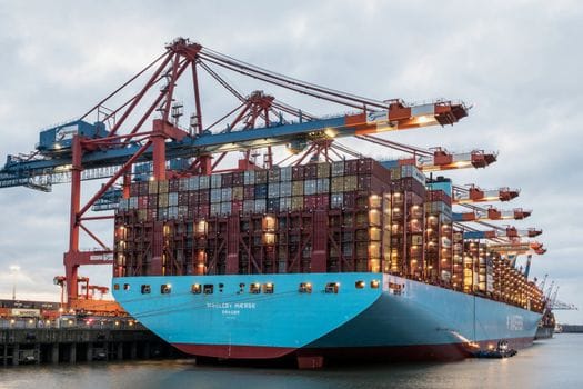 Cum să Obții Certificatul Radio VHF GMDSS pentru Navigația Pe Mări Internaționale 4 Large container ship at Hamburg port with cranes, showcasing global trade industry.