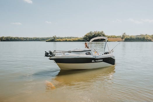 Motorboat on a calm lake with a clear sky and lush greenery in the background, perfect summer day.