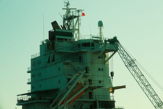 Cursuri Online RYA Navigație și Securitate vs Opțiuni Tradiționale: Ghid Complet pentru Certificare 2 Close-up of an industrial ship's structure and crane against a sunset backdrop.