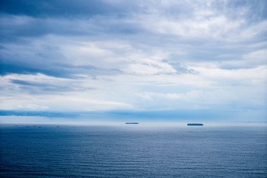 Pași pentru Obținerea Certificat STCW pentru Tanker Petrolier: Ghid Compleț 4 Peaceful ocean view with distant ships under a cloudy sky.
