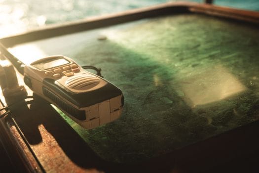 Pași pentru Pregătirea Eficientă la Examenul Radiotelefonist GMDSS: Cerințe și Beneficii pentru Navigatorii Români 3 A vintage walkie talkie placed on a sunlit table, conveying communication and nostalgia.