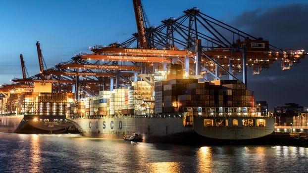 Cât de Pregătiți Sunt Ofițerii de Punte Recenți din România pentru Piața Muncii Maritimă în 2026? 2 Vibrant evening view of cargo operations at Terminal Burchardkai, Hamburg.