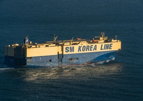 Cât de Pregătiți Sunt Ofițerii de Punte Recenți din România pentru Piața Muncii Maritimă în 2026? 4 A large cargo ship, SM Korea Line, navigating through calm ocean waters under a clear blue sky.