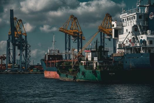 Opportunity Learning vs Inscrieri la Academia Navală: Alegerea Ideală pentru Cariera ta Maritimă în 2026? 2 Cargo ships and cranes in an industrial port in Istanbul. Captured on a cloudy day.