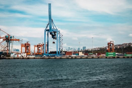 Pași esențiali pentru obținerea certificatelor STCW: ghid complet 2 View of an industrial port in Istanbul with cranes and cargo containers against the city skyline.