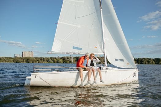 Top 5 Inițiative de Educație Maritimă care Transformă Cariera pe Mare în România, Vară 2026 3 Grandfather bonds with grandson while sailing a white boat on a sunny lake day.