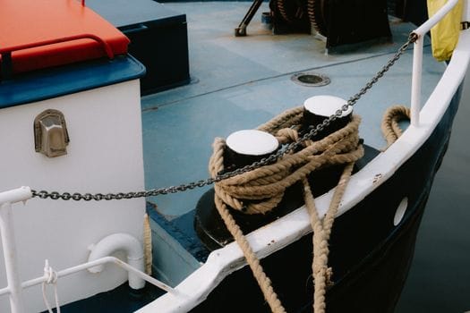 Top 7 Reglementări IMO care Transformă Educația Maritimă în România în Iulie 2026 2 Detailed view of a boat deck showcasing robust mooring ropes and chain, ideal for marine-themed content.