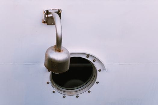 Training Maritim Avansat vs Cursurile de Bază STCW: Ce Alegi pentru Cariera ta în Vară 2026? 3 A detailed view of a ship's porthole and vent, showcasing maritime design elements.