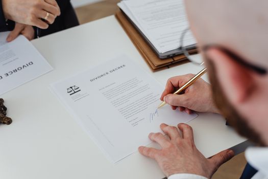 Cum Influențează Scrisoarea de Intenție Aprobarea Contractelor Maritime Internaționale în 2026? 2 Close-up of a person signing a divorce decree on a desk.