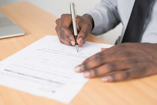 Cum Influențează Scrisoarea de Intenție Aprobarea Contractelor Maritime Internaționale în 2026? 3 Close-up of a businessman signing a contract at an office desk.