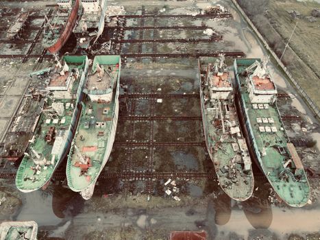 Cum Poți Accesa Cele Mai Atractiv Remunerate Locuri de Muncă pentru Marinari în România, August 2026? 3 Aerial view of derelict ships in an abandoned shipyard, creating an industrial decay scene.