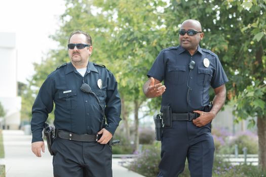 Cum Te Influențează Pregătirea STCW din Vară 2026 la Redactarea Scrisorii de Intenție pentru Angajarea pe Mare? 2 Two police officers walking outdoors, wearing uniforms and sunglasses, engaged in conversation.