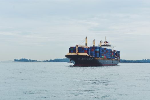 Este Costul sau Flexibilitatea Principalul Avantaj al Cursurilor Online pentru Certificarea STCW în România, August 2026? 3 Large cargo ship transporting containers across a calm sea, symbolizing global logistics.