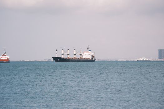 Mituri vs Realitate: De ce Scrisoarea de Intenție nu este Doar un Formalism în Cariera Maritimă 3 A cargo ship sails in Izmir Bay with city skyline in the background, captured on a clear day.