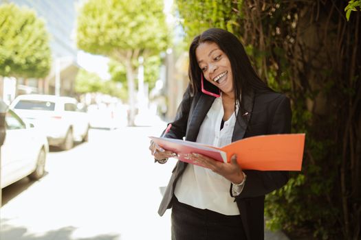 Scrisoarea de Intenție vs Cerințele pentru Angajare: Ce Contează Mai Mult în Cariera Maritimă? 4 Confident businesswoman multitasks while talking on the phone and reviewing documents outdoors.