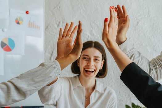 Top 5 Aspecte de Luat în Considerare la Scrierea unei Scrisori de Intenție pentru o Carieră Maritimă 2 Diverse colleagues share a joyful high five, showcasing teamwork and unity in the office.