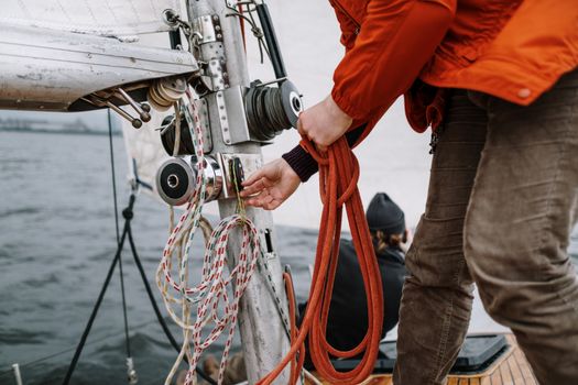 Top 5 Cerințe Pentru a Deveni Master Seaman în 2026 2 Close-up of a sailor handling ropes on a sailboat during a nautical expedition.