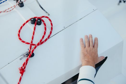 Top 5 Cerințe Pentru a Deveni Master Seaman în 2026 4 Close-up of a man's hand touching a sailboat deck with ropes, depicting nautical themes.