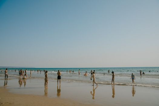 Top 5 Instrumente de Automatizare SEO pentru Cursuri și Certificări STCW în România 3 A vibrant beach scene with people relaxing and playing in the ocean under a clear sky.