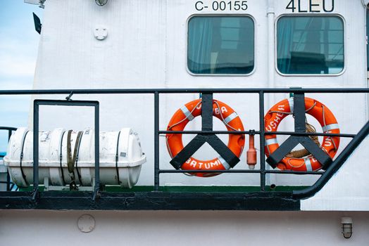 Close-up of life preservers and buoyancy aids on a docked ship, emphasizing marine safety.