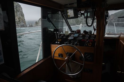 Top 7 Companii de Shipping din România care Revoluționează Formarea Profesională pentru Certificările STCW 3 Explore the rugged coastline's beauty from a boat cockpit with stunning rocky views.