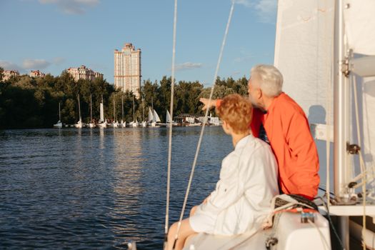 Top 7 Elemente Esențiale pentru o Scrisoare de Intenție de Succes în Shipping 2 A grandfather and grandson sailing on a lake, pointing towards the horizon under a blue sky.