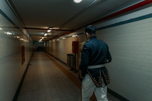 A historical reenactor dressed as a colonial guard walks through an empty subway tunnel in Buenos Aires.