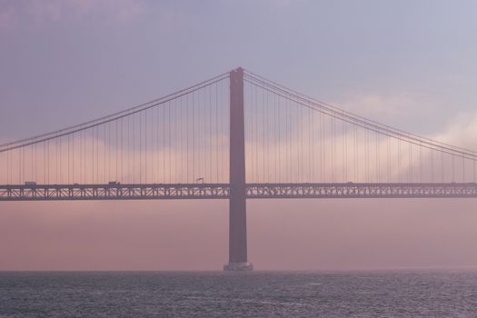 Scenic view of Ponte 25 de Abril in Lisbon, Portugal, capturing the iconic suspension bridge at dusk.