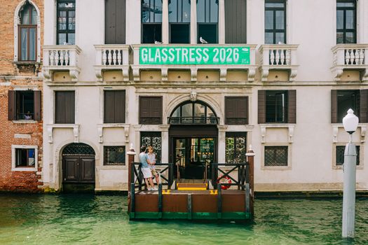 Top 5 Avantaje ale Carierei de Radiotelefonist pe Mare în 2026 2 People standing in front of a Venetian building with a Glasstress 2026 banner over a canal.