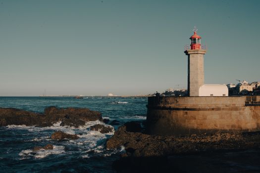 Top 5 Avantaje ale Carierei de Radiotelefonist pe Mare în 2026 3 A scenic view of a historic lighthouse overlooking the Atlantic Ocean on Portugal's rocky coast in Porto.